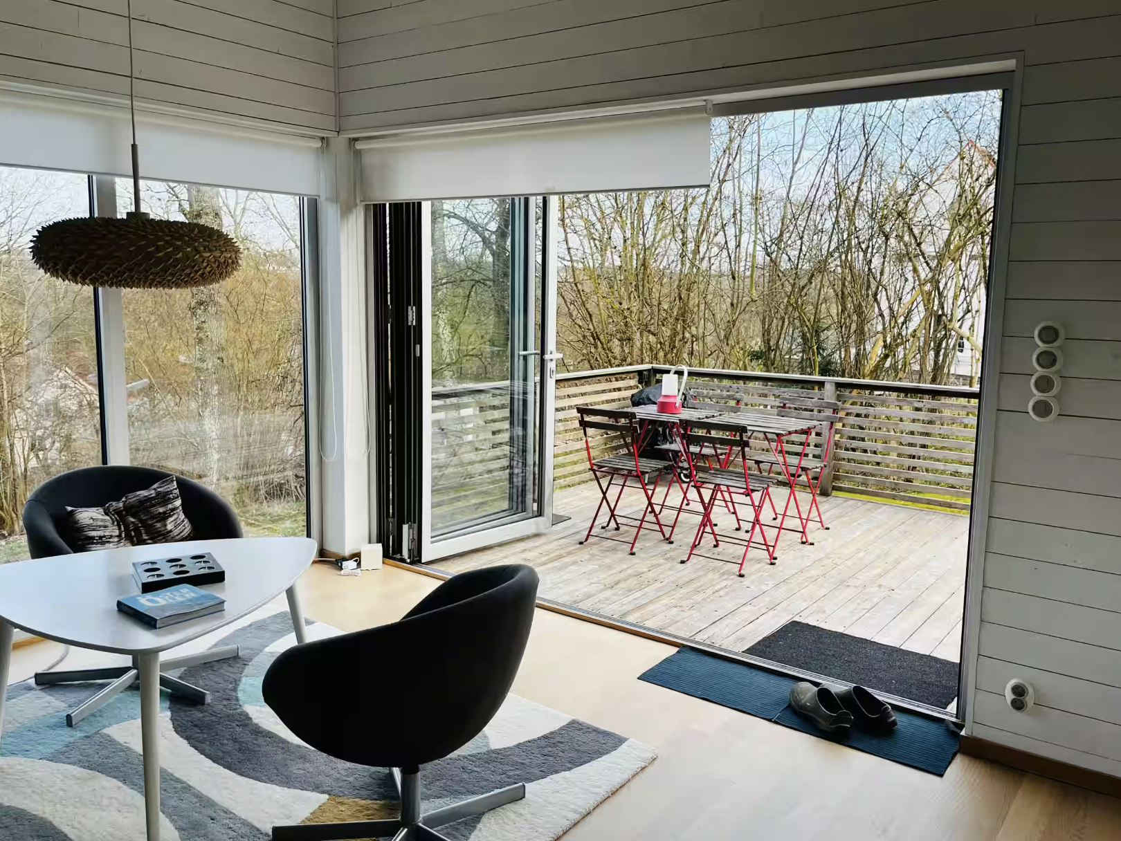 Allrummet med öppna glasdörrar mot terrassen.